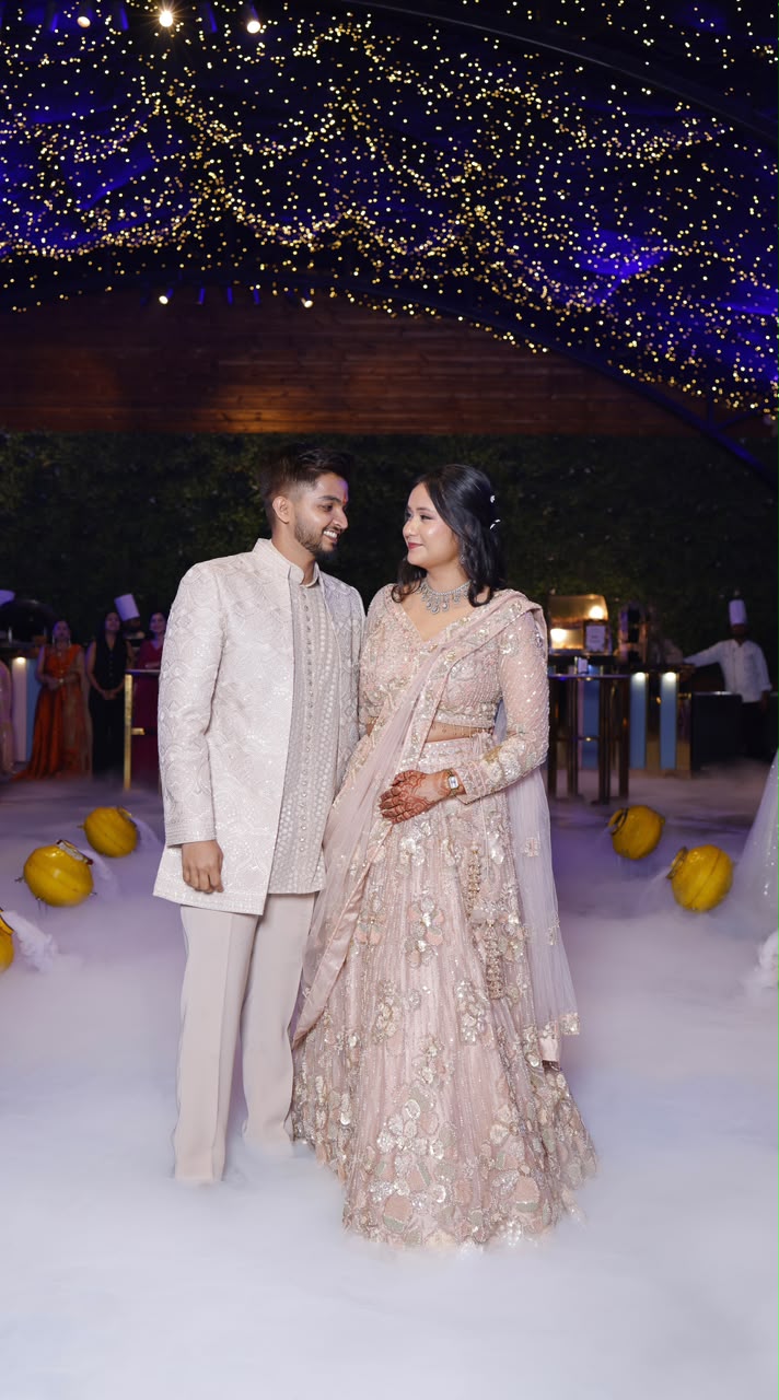Couple in blush lehenga under fairy lights